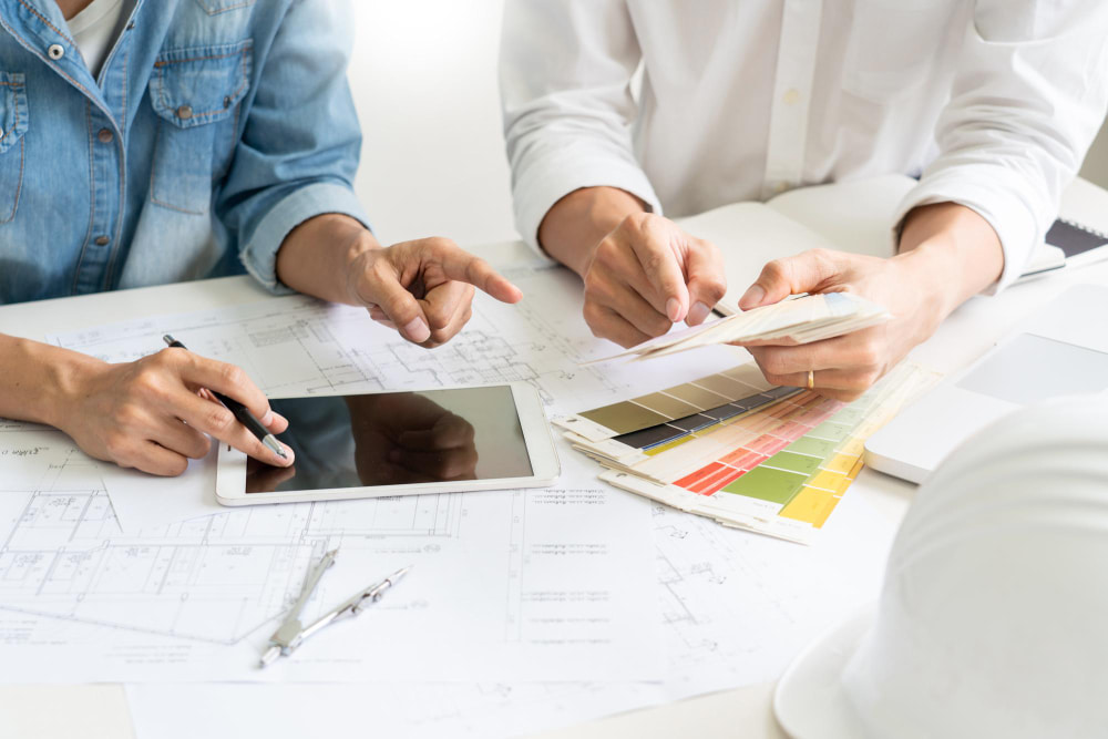 A team of designers collaborating to plan a kitchen remodeling, discussing layouts and color schemes.