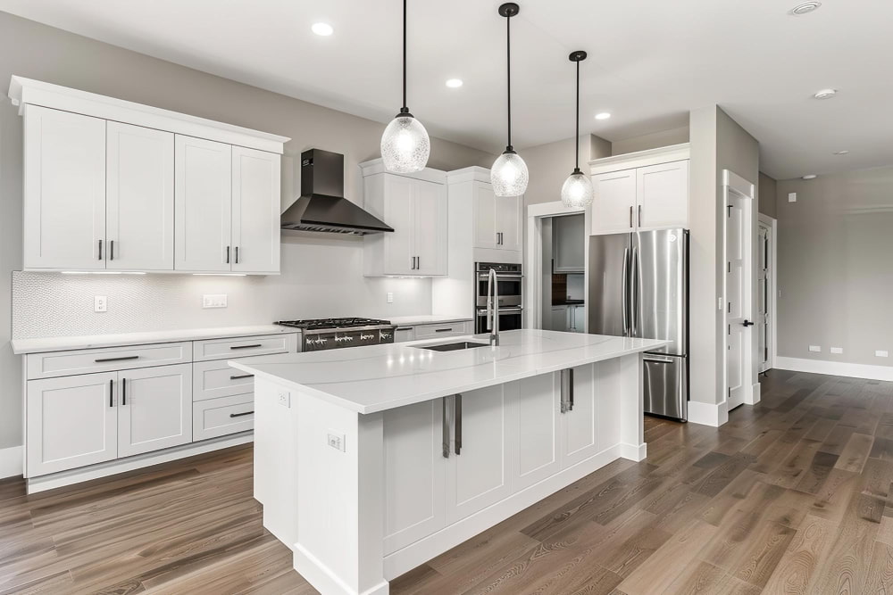 Modern kitchen with white cabinets and stainless steel appliances, illustrating kitchen remodeling cost options.