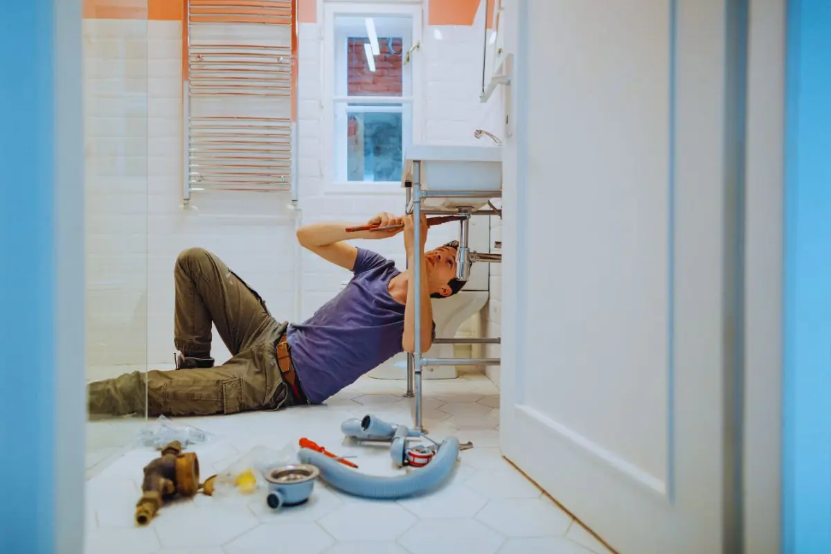 Man solving plumbing problems in his bathroom