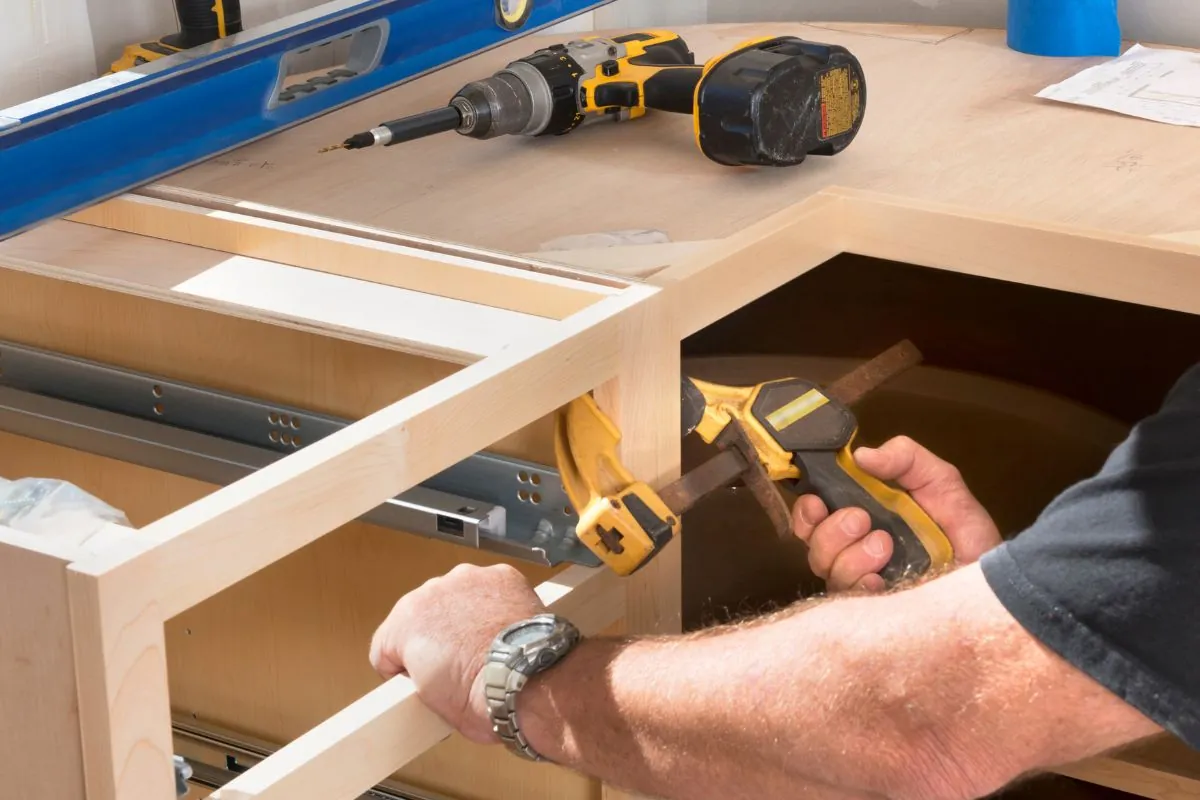 construction worker installing kitchen cabinets