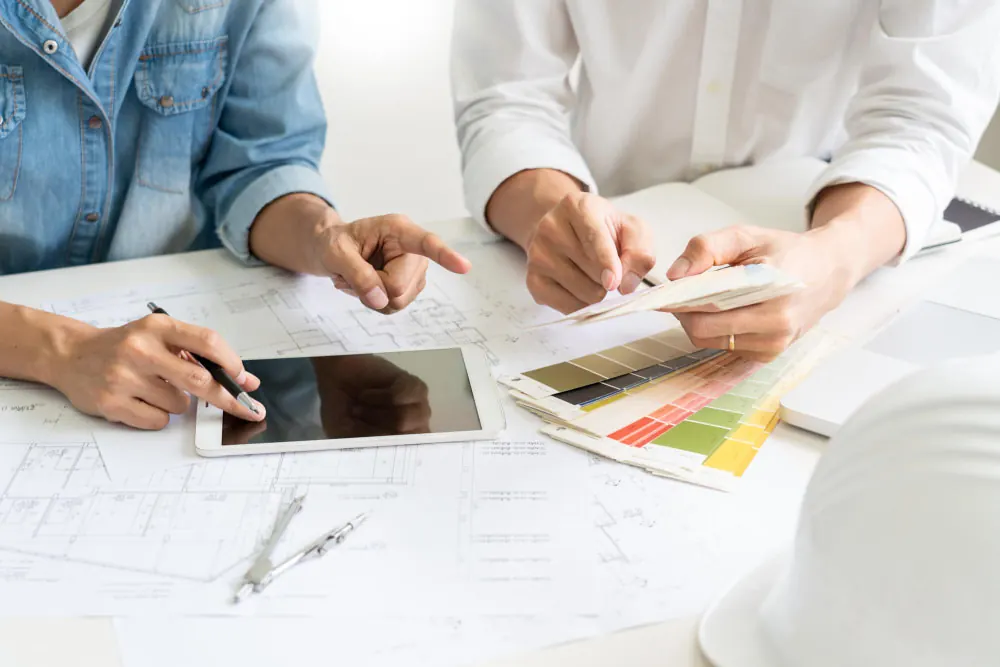 A team of designers collaborating to plan a kitchen remodeling, discussing layouts and color schemes.