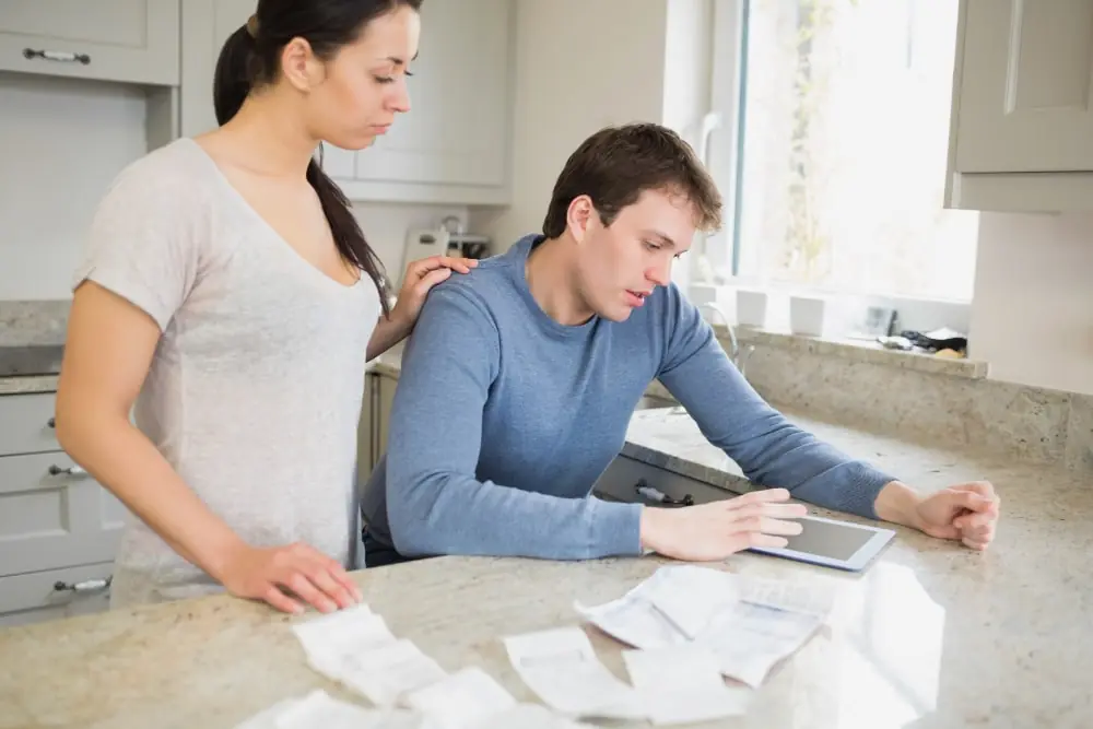 Couple reviewing kitchen remodeling costs and plans, focusing on budgeting and expenses.