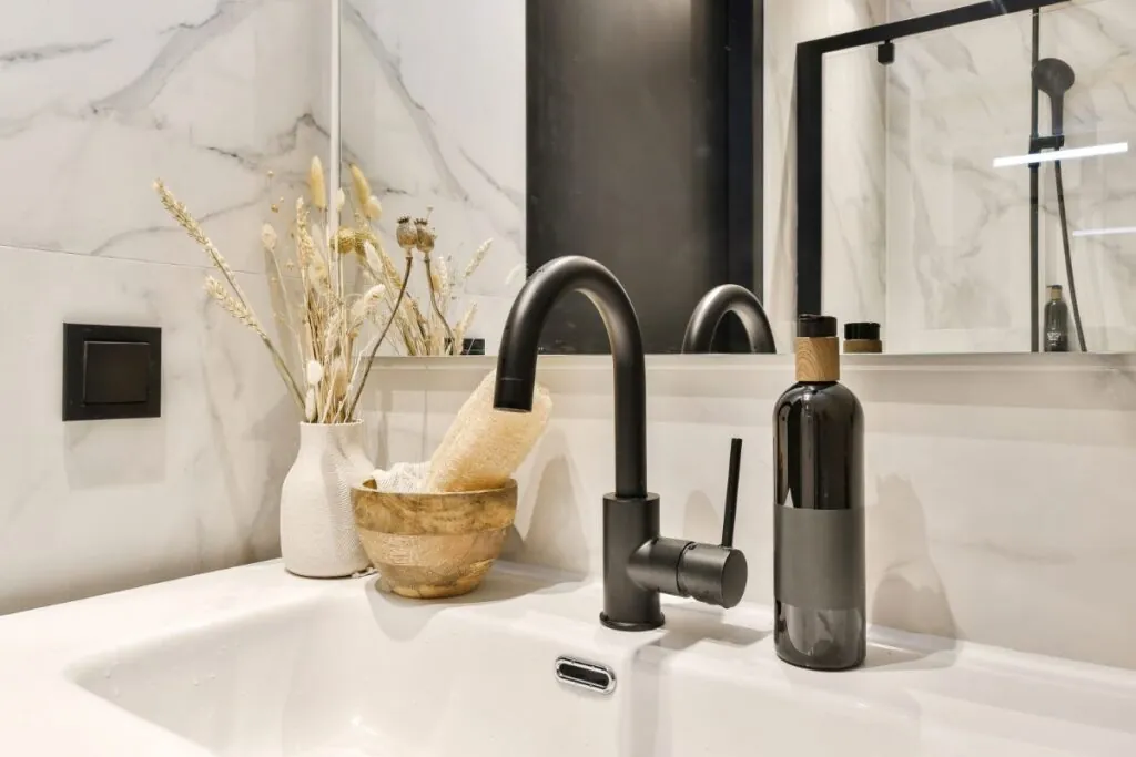 a white bathroom sink with a black faucet