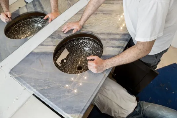 bathroom remodeling contractor installing granite countertops and sink