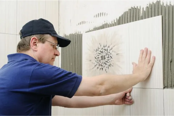 bathroom renovator installing ceramic tiles for bathroom wall